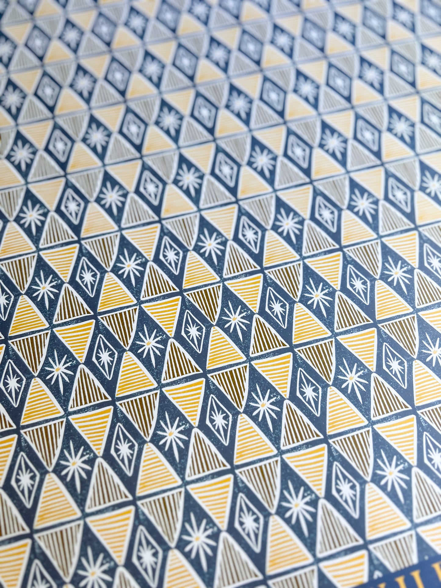 close up of a blue and yellow harlequin patterned wrapping paper sheet