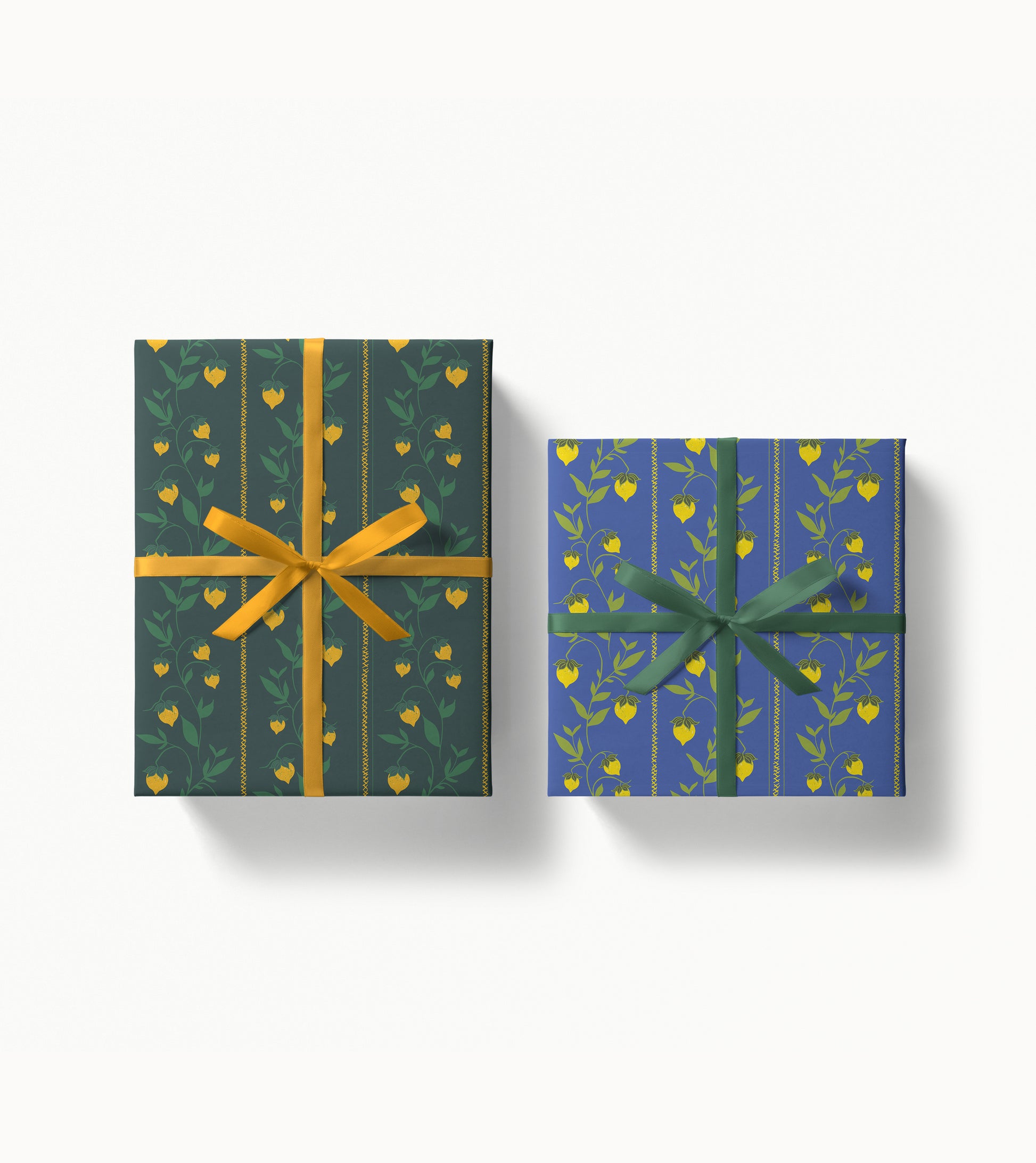 Two wrapped gift boxes with berry vine decorative patterned paper and ribbons on a white background