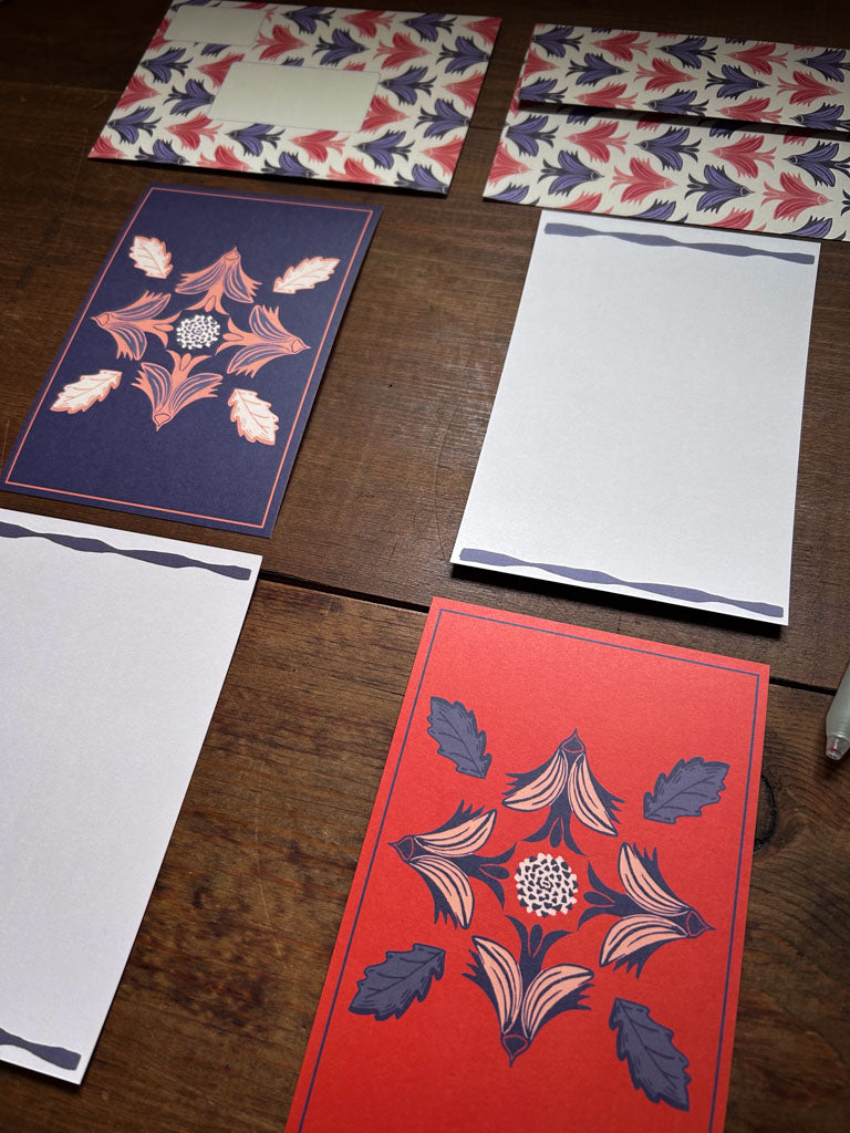 Decorative greeting cards with floral and bird patterns on a wooden surface 