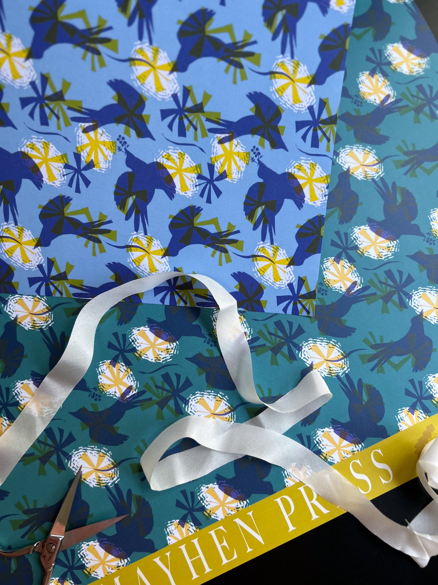 close up of double sided wrapping paper sheet featuring darker and lighter colorways and a bird pattern