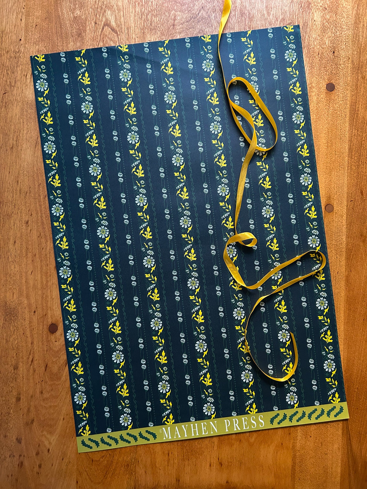 wrapping paper sheet with floral stripe pattern on a dark green background 