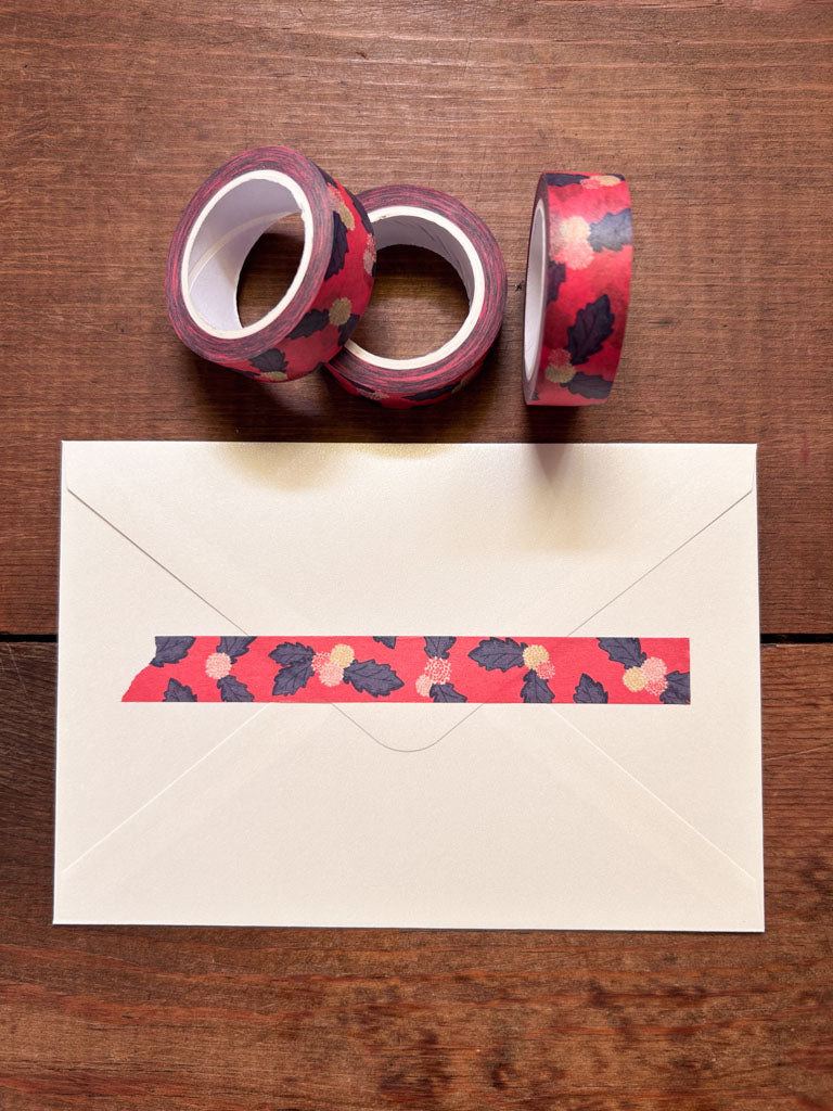 Two rolls of floral tape and an envelope with a strip of tape on a wooden surface