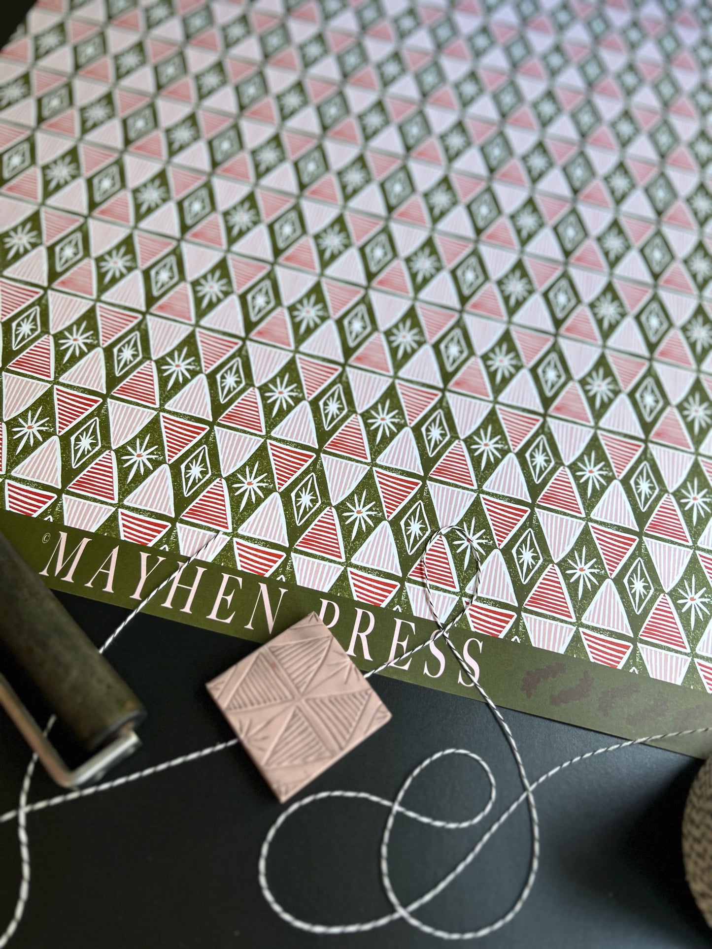 red and green harlequin patterned crafting paper sheet with 'Mayhen Press' branding