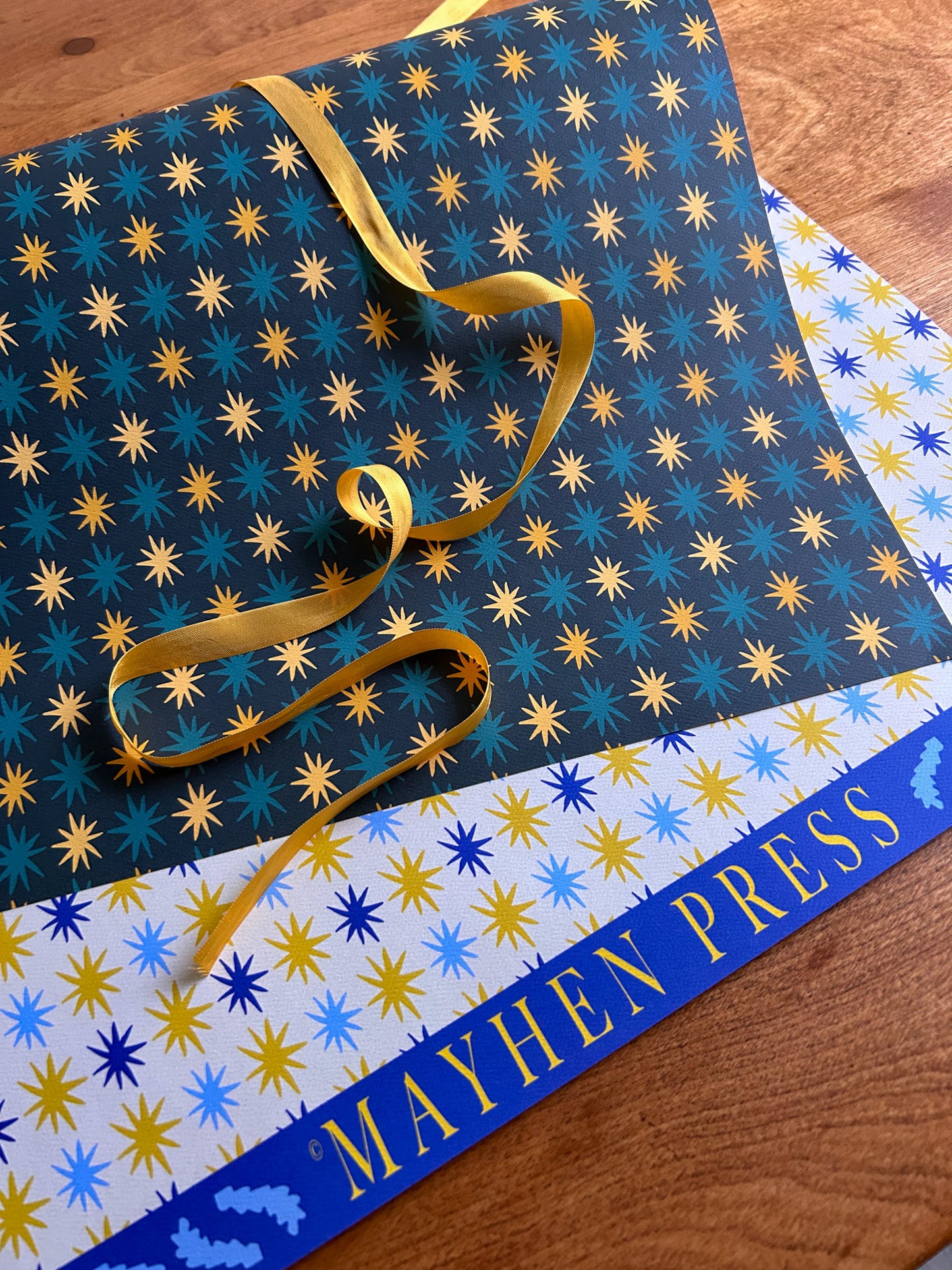 A double-sided pattern sheet with a star pattern, featuring blue and yellow stars on a darker background on one side and blue and yellow stars on a lighter background on the other
