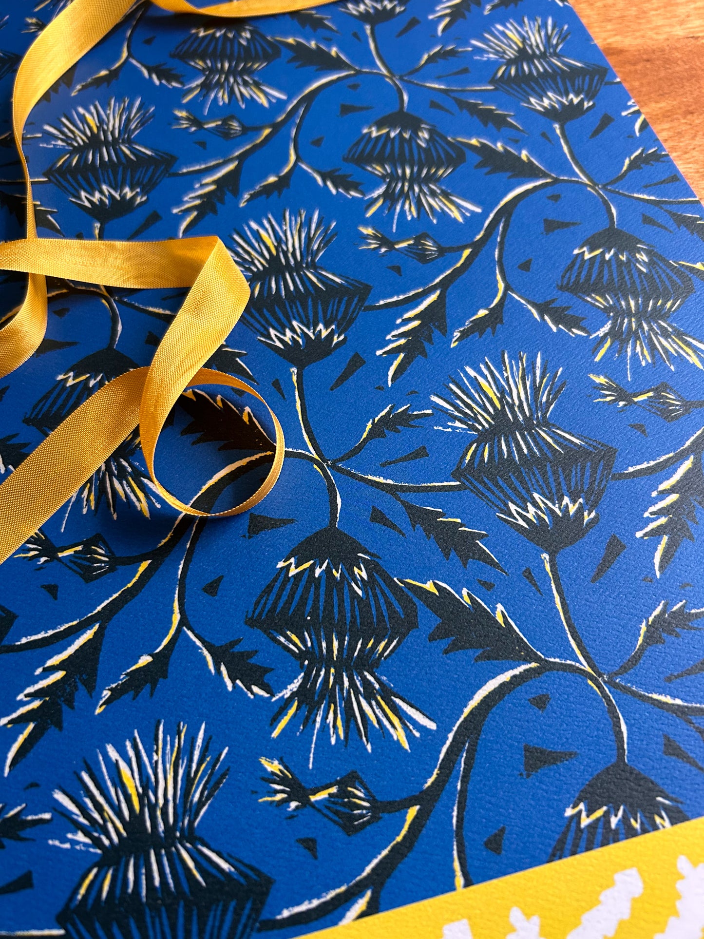 close up of thistle flower patterned crafting paper on blue background
