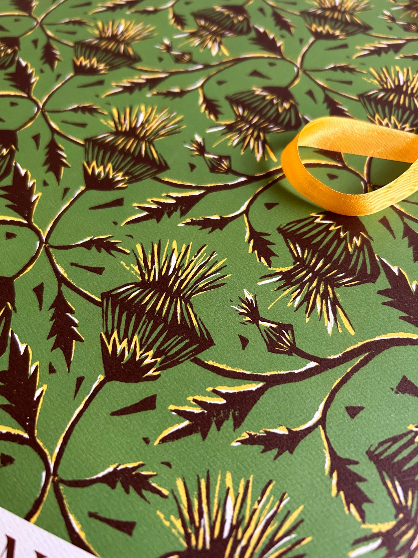 close up of thistle flower patterned crafting paper on green background