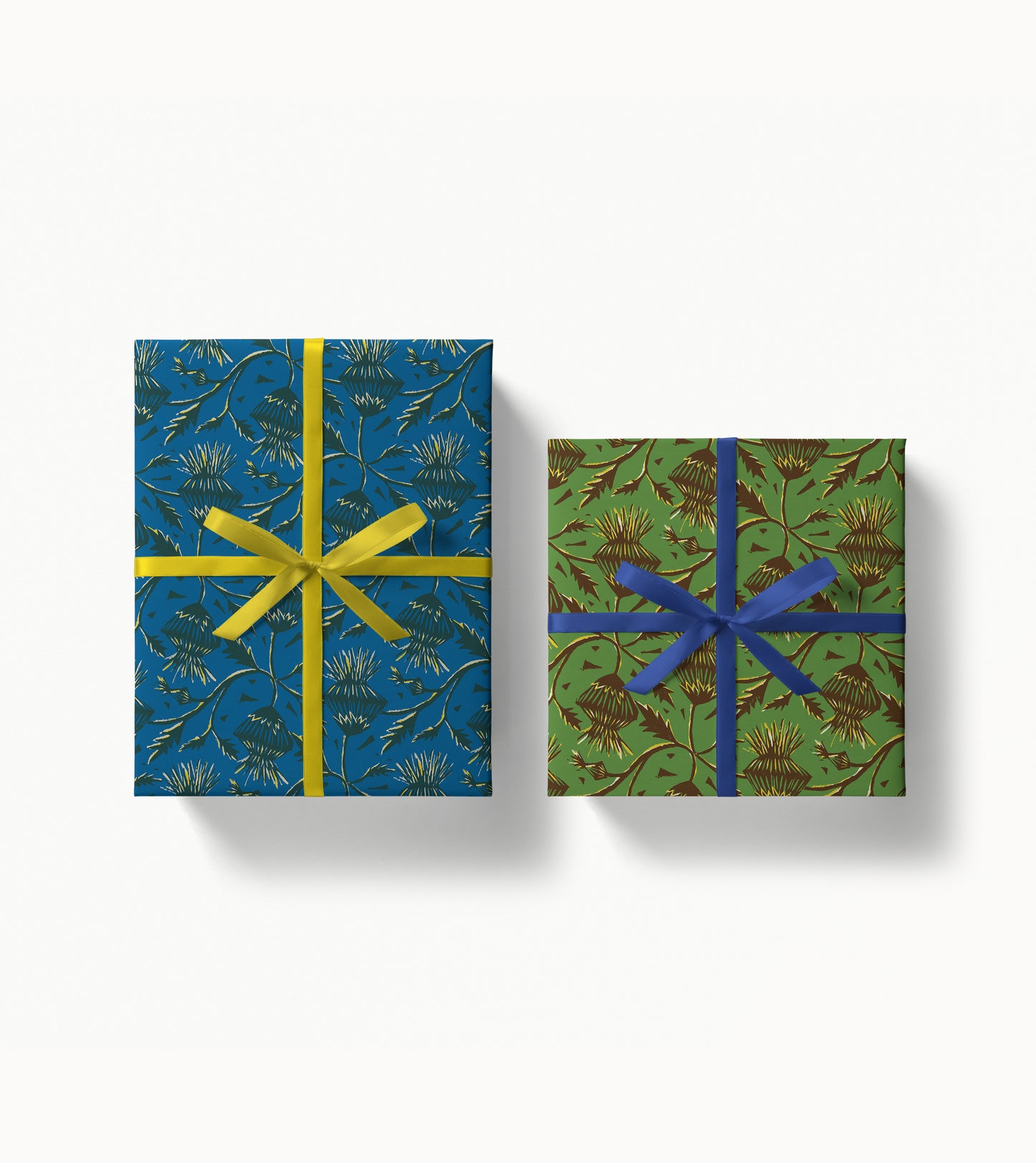 Two wrapped gift boxes with decorative patterned paper and ribbons on a white background