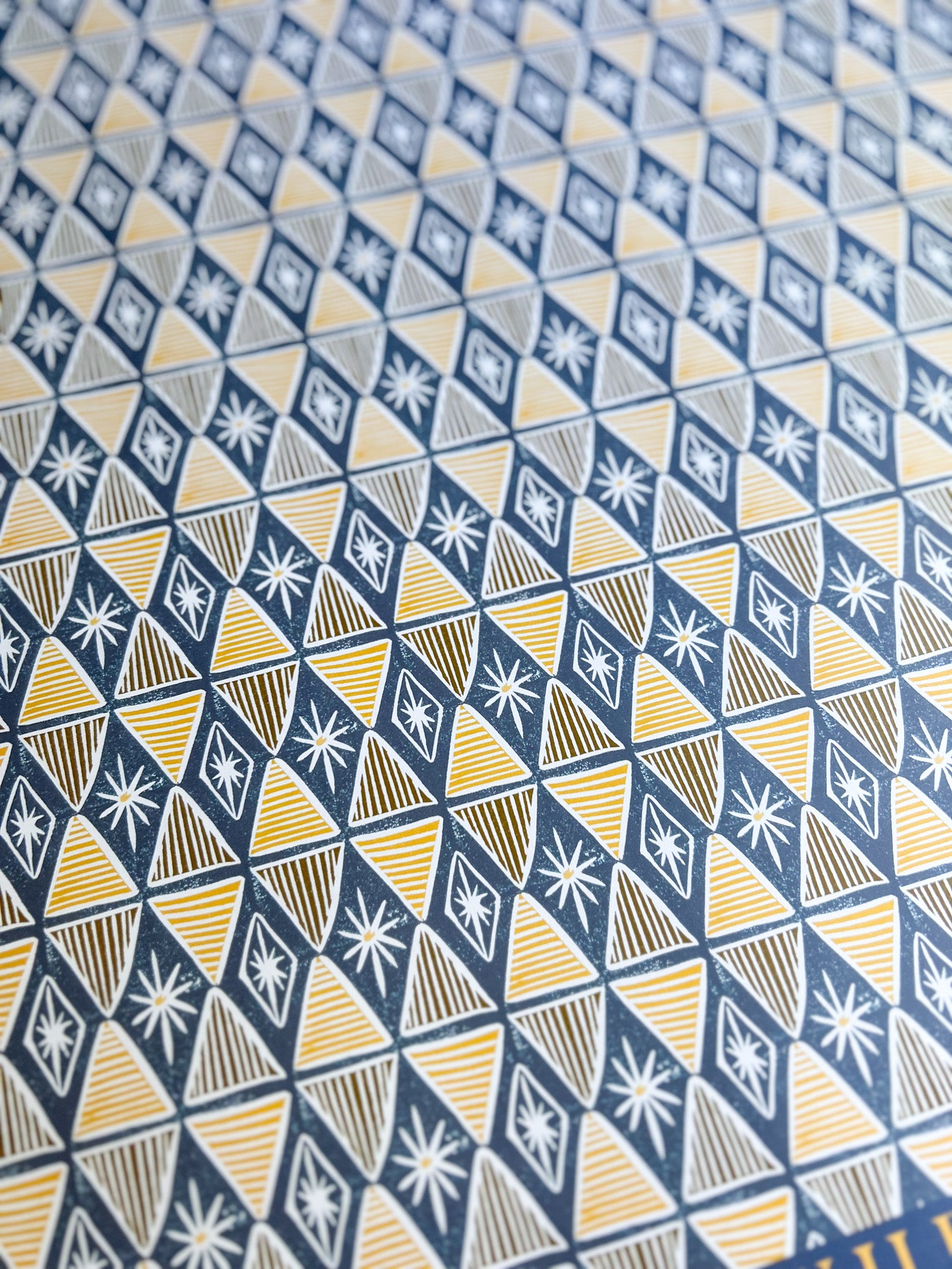 close up of a blue and yellow harlequin patterned wrapping paper sheet