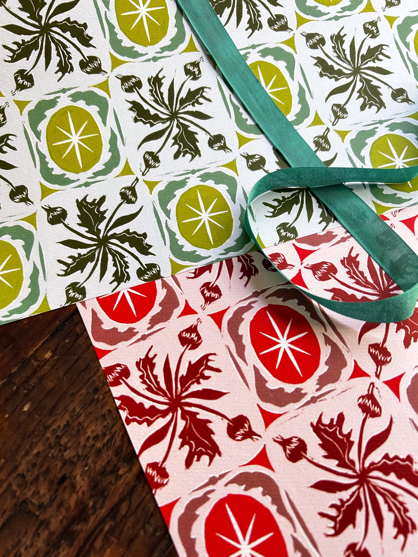 close up of double sided wrapping paper sheet with botanical buds and stars pattern in green and red olorways