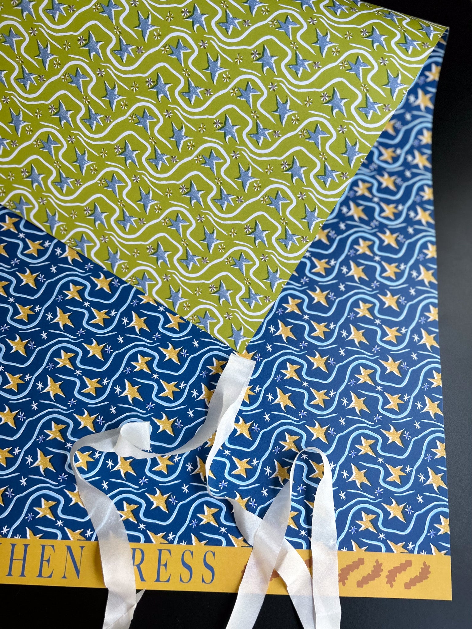 double sided star patterned crafting paper sheet featuring yellow stars on a blue background and blue stars on a green background